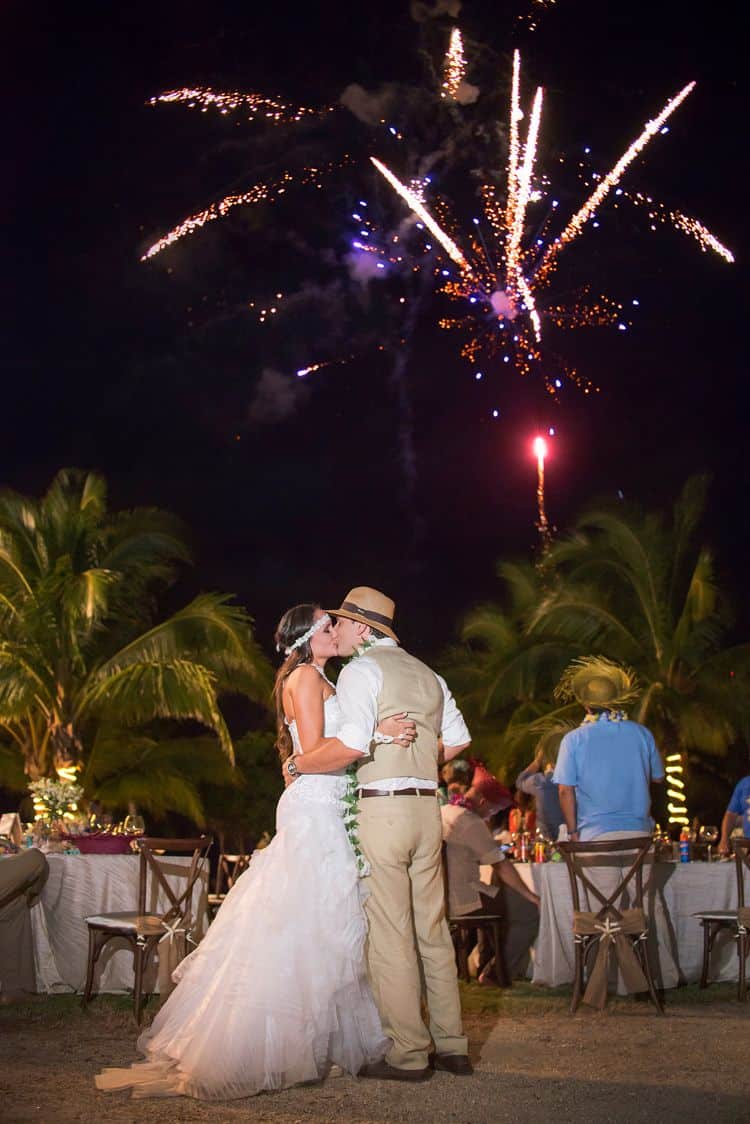 Photo of bride and groo with fireworks going off in the background