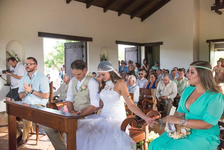 The bride and maid of honor holding hands during the wedding ceremony