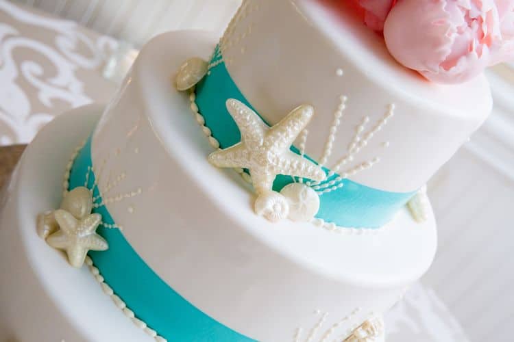 Gorgeous beach wedding cake in white and aqua with pink flowers