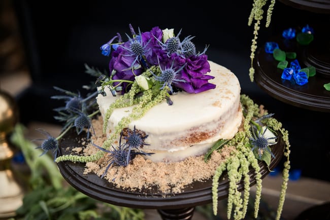 Gorgeous beach wedding cake with faux sand and jewel toned flowers