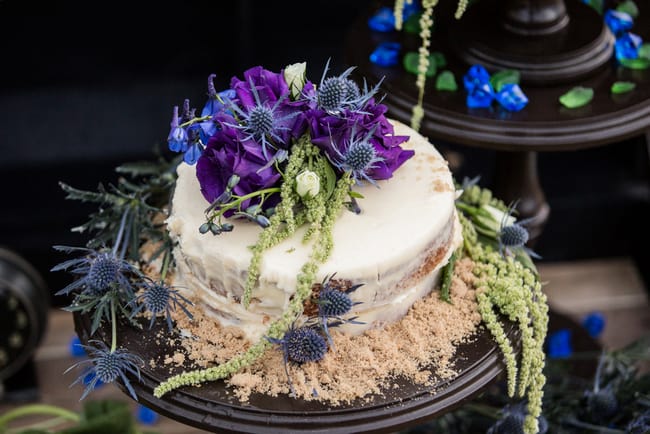 beach wedding cake with faux sand and jewel toned flowers