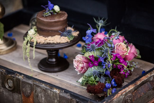 beach wedding chocolate cake with faux sand and jewel toned flowers
