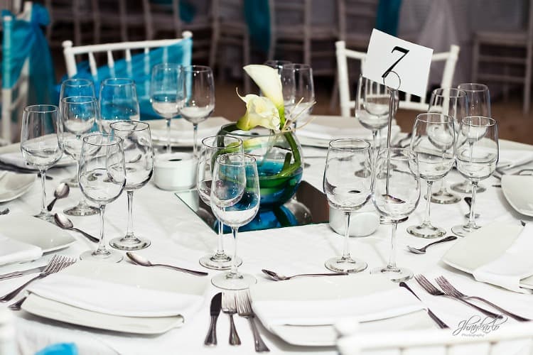 White and blue wedding decorations on a white table on a beach