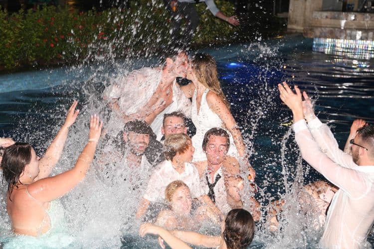 The bridal party jumping into the pool at a destination wedding in Cancun