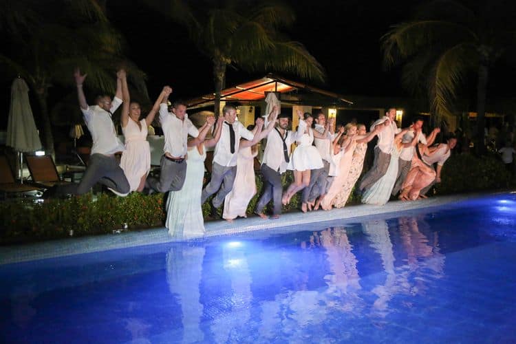 The bridal party jumping into the pool at a destination wedding in Cancun