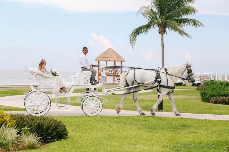 The bride arriving in a horse drawn carriage for her destination wedding at the Moon Palace