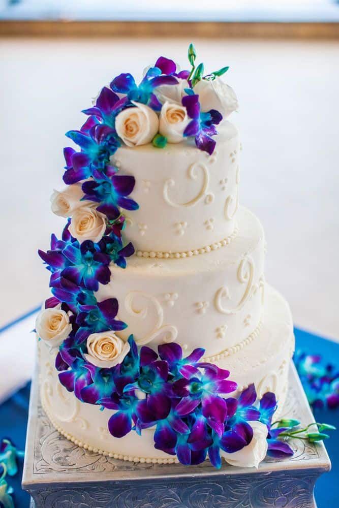 wedding cake with blue and purple orchid flowers